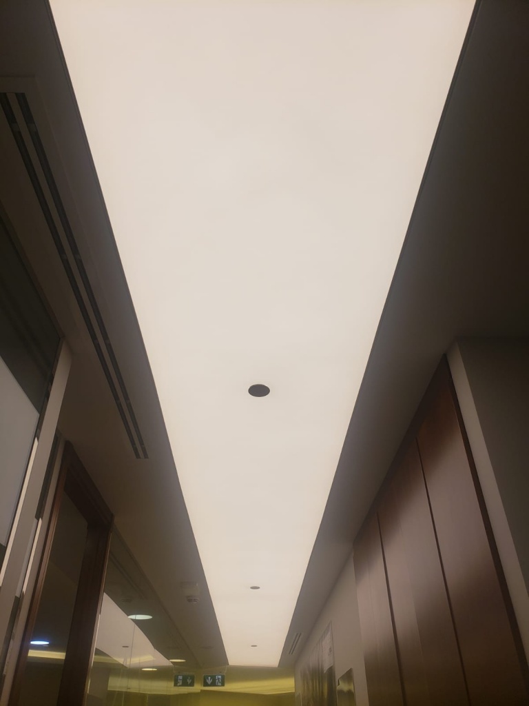 Translucent stretch ceiling light box with 4000K LED lighting installed in a corridor interior in Dubai