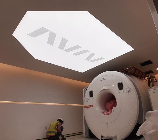 Custom printed stretch ceiling with clinic logo and integrated lighting system for a contemporary diagnostic room. Custom printed stretch ceiling with clinic logo and integrated lighting system for a contemporary diagnostic room.