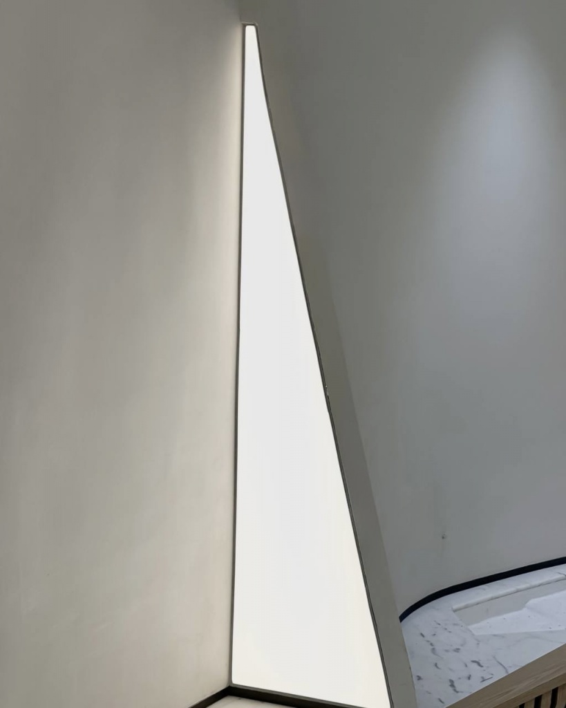 Modern architectural light ceiling with curved illuminated elements and seamless recessed installation in a premium corporate office. Modern architectural light ceiling with curved illuminated elements and seamless recessed installation in a premium corporate office.