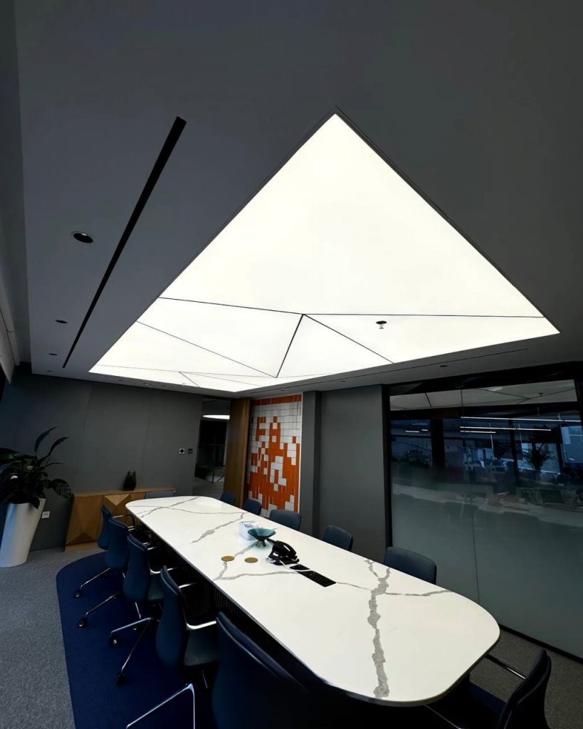 Large 3D illuminated stretch ceiling with geometric light panels installed in a modern corporate meeting room in Deira. Large 3D illuminated stretch ceiling with geometric light panels installed in a modern corporate meeting room in Deira.