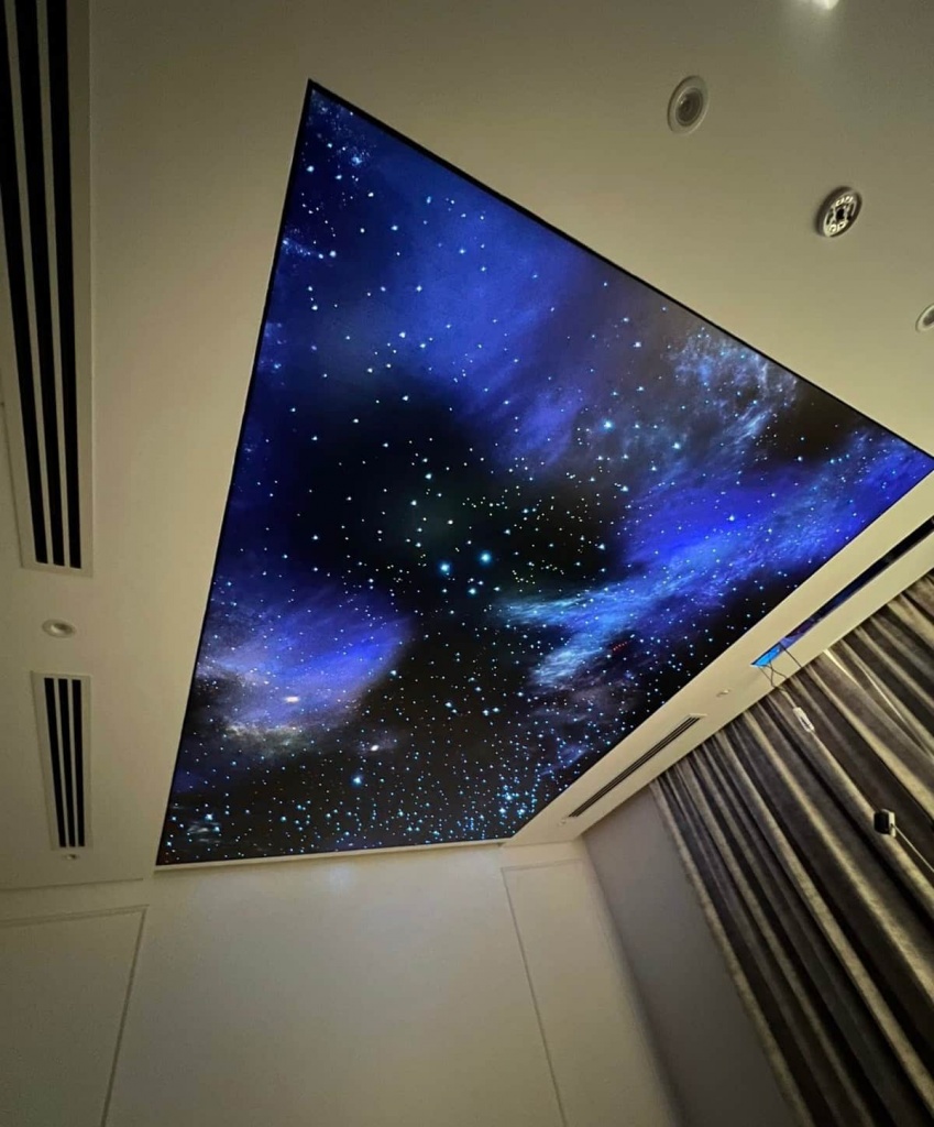 Galaxy-inspired illuminated stretch ceiling with deep space effect and integrated architectural lighting. Galaxy-inspired illuminated stretch ceiling with deep space effect and integrated architectural lighting.