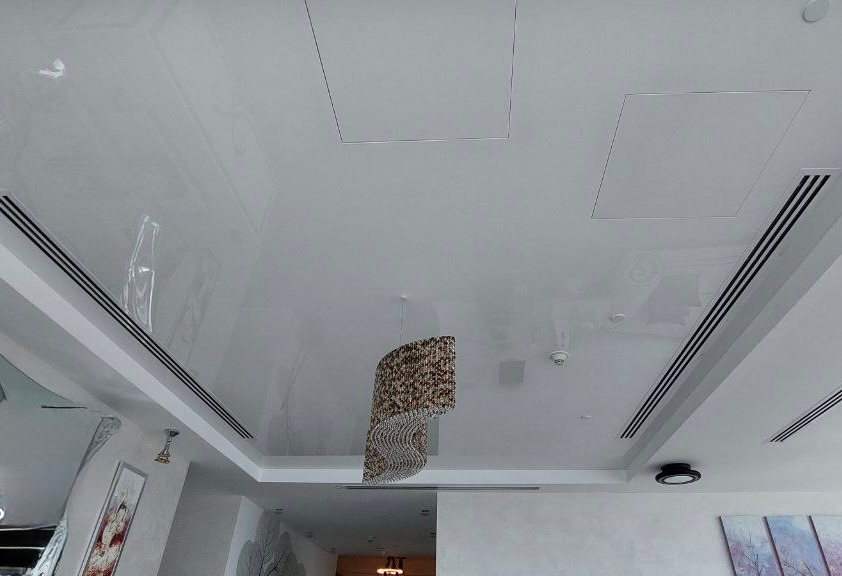 Seamless white high-gloss ceiling enhancing natural daylight and spaciousness in a contemporary Dubai apartment. Seamless white high-gloss ceiling enhancing natural daylight and spaciousness in a contemporary Dubai apartment.