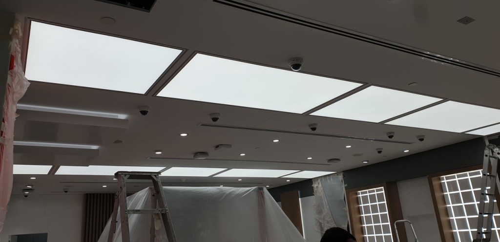 Damaged illuminated stretch ceiling in Dubai with visible discoloration and membrane deformation requiring professional repair and restoration. Damaged illuminated stretch ceiling in Dubai with visible discoloration and membrane deformation requiring professional repair and restoration.