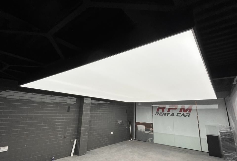 Backlit stretch ceiling light box with 4000K LED lighting in car rental office in Al Quoz Dubai