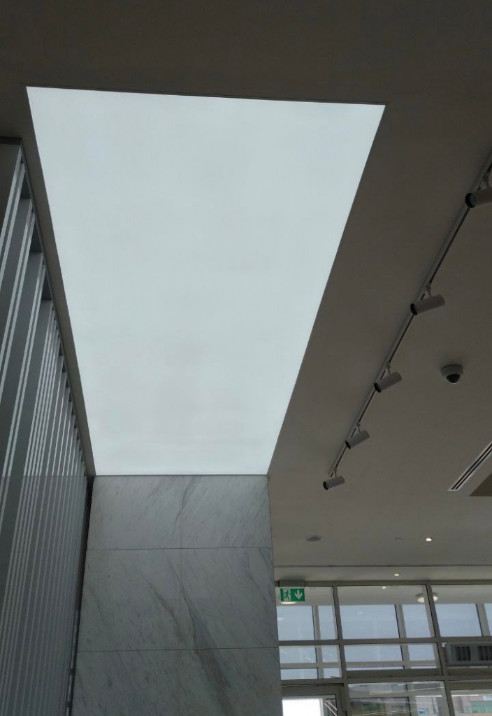 Large illuminated ceiling panel creating soft ambient lighting in a modern luxury interior. Large illuminated ceiling panel creating soft ambient lighting in a modern luxury interior.
