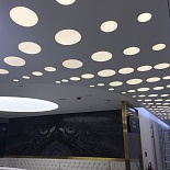 White satin stretch ceiling with decorative circle shape light