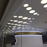 White satin stretch ceiling with decorative circle shape light